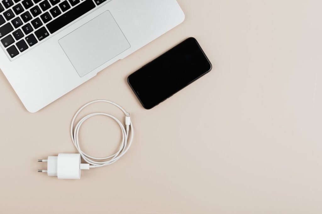 Laptop charger connected to a modern laptop on a workspace desk
